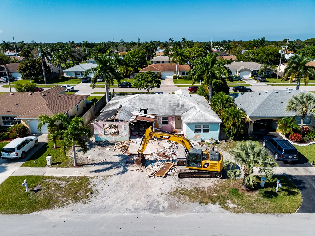 Older Hollywood FL residential home being demolished by excavator in South Broward County neighborhood